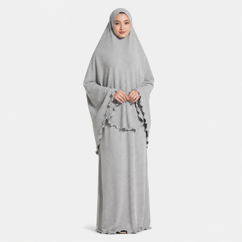 Woman wearing a gray abaya with a matching hijab on a white background