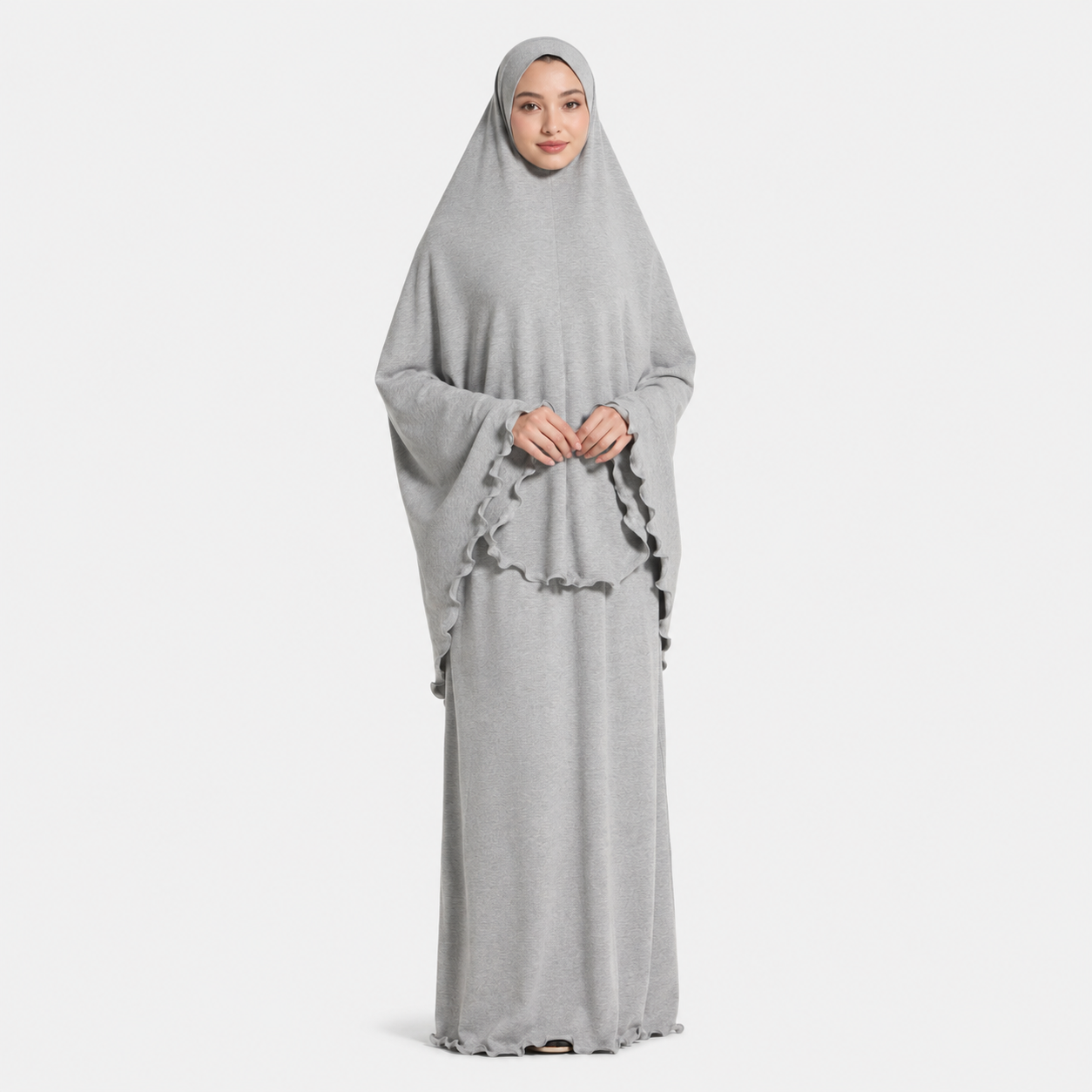 Woman wearing a gray abaya with a matching hijab on a white background