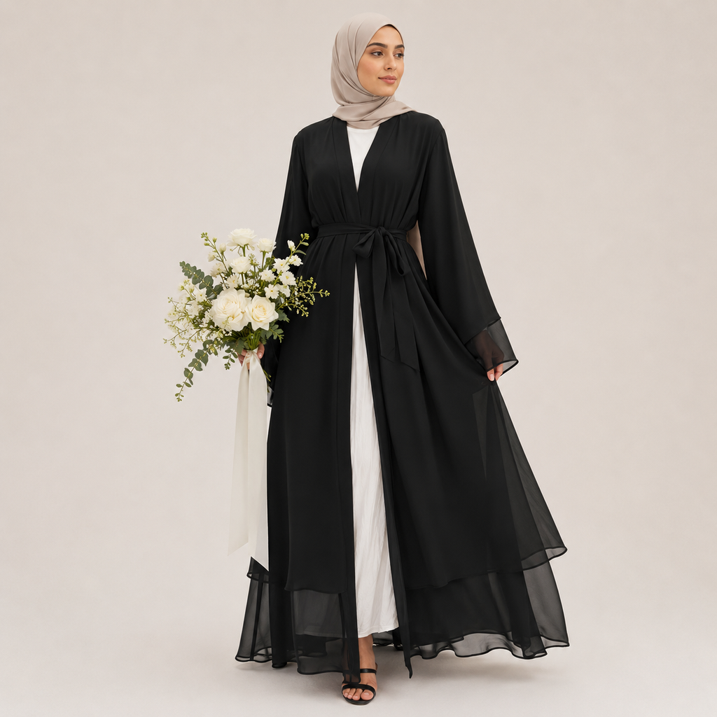 Woman wearing a black abaya with a white dress underneath, holding flowers on a plain background