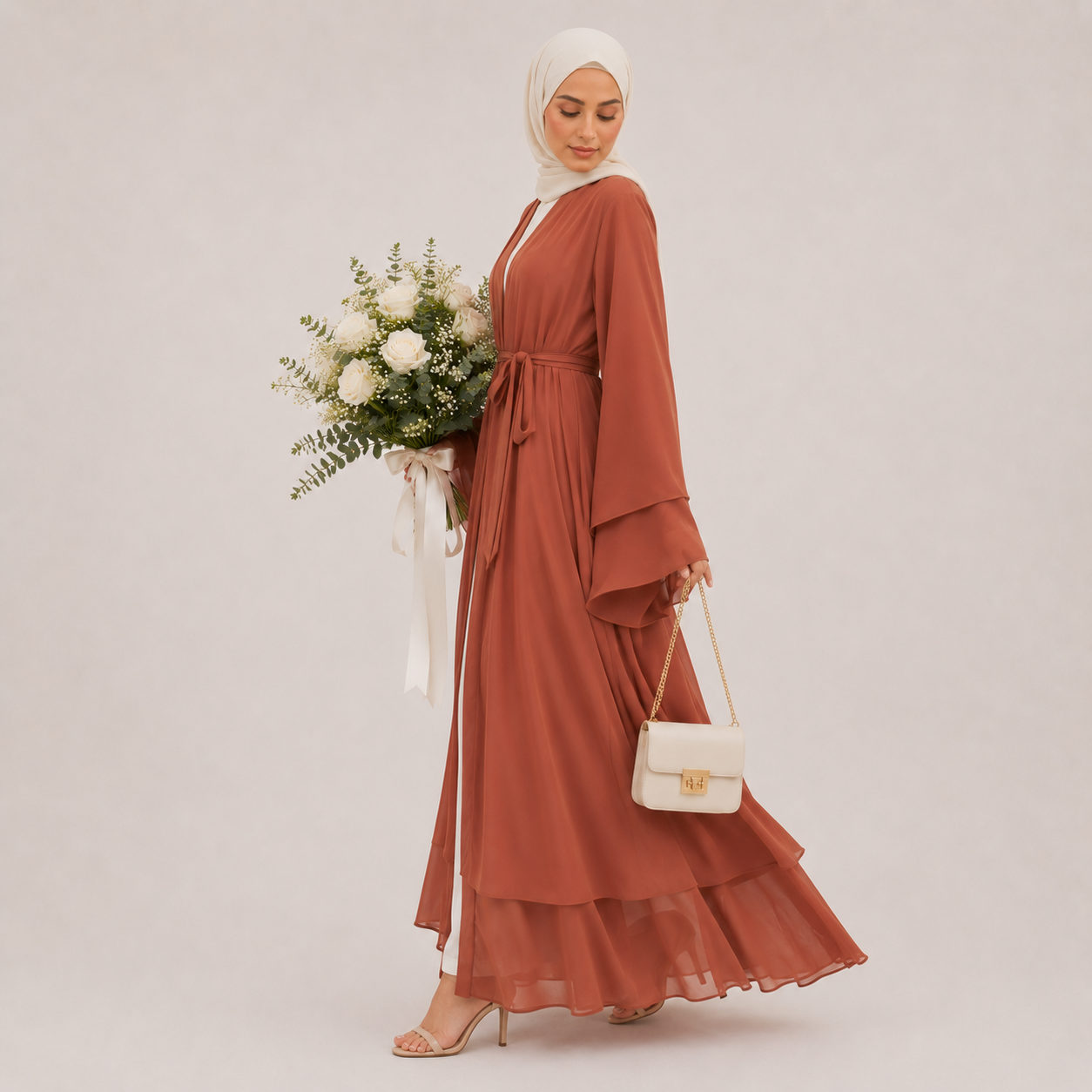 Woman in a rust-colored dress holding a bouquet of flowers and a white handbag on a plain background