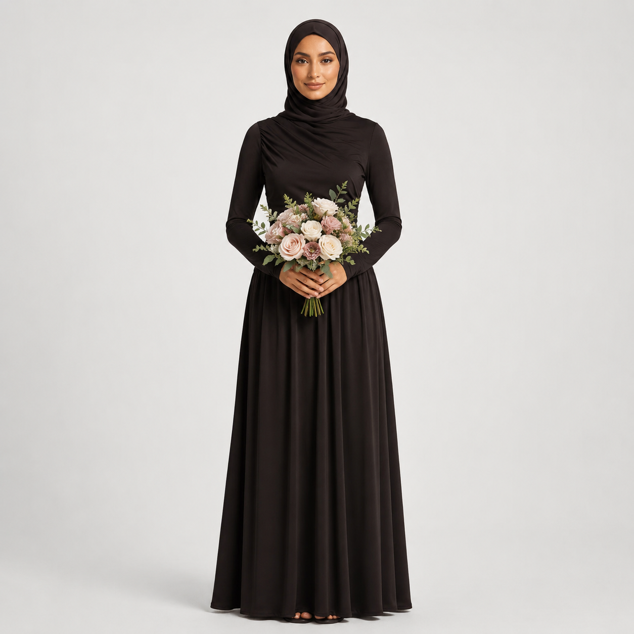 Woman in a long black dress holding a bouquet of flowers on a light gray background