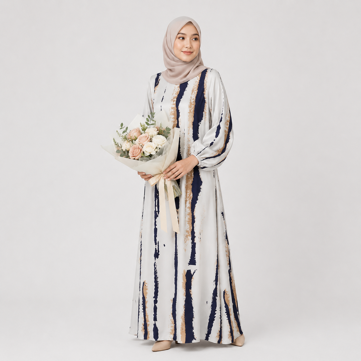Woman wearing a long, patterned dress holding a bouquet of flowers on a plain background