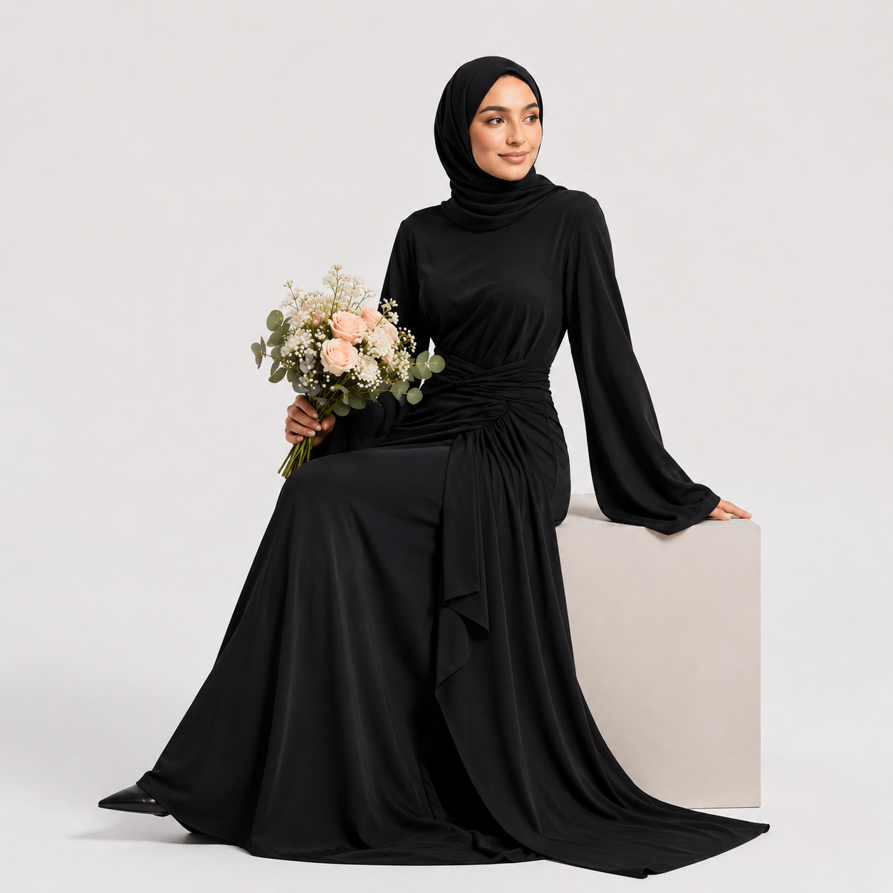 Woman wearing a black hijab and black dress holding a bouquet of flowers on a white background