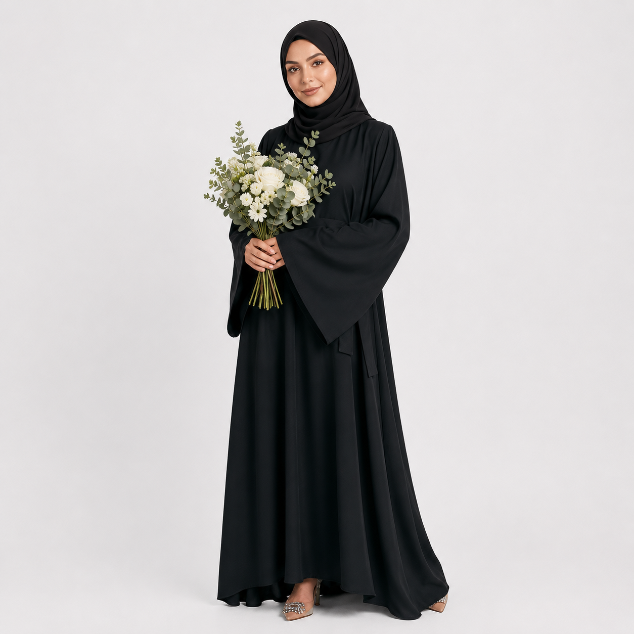 Woman in a black abaya holding a bouquet of flowers on a white background
