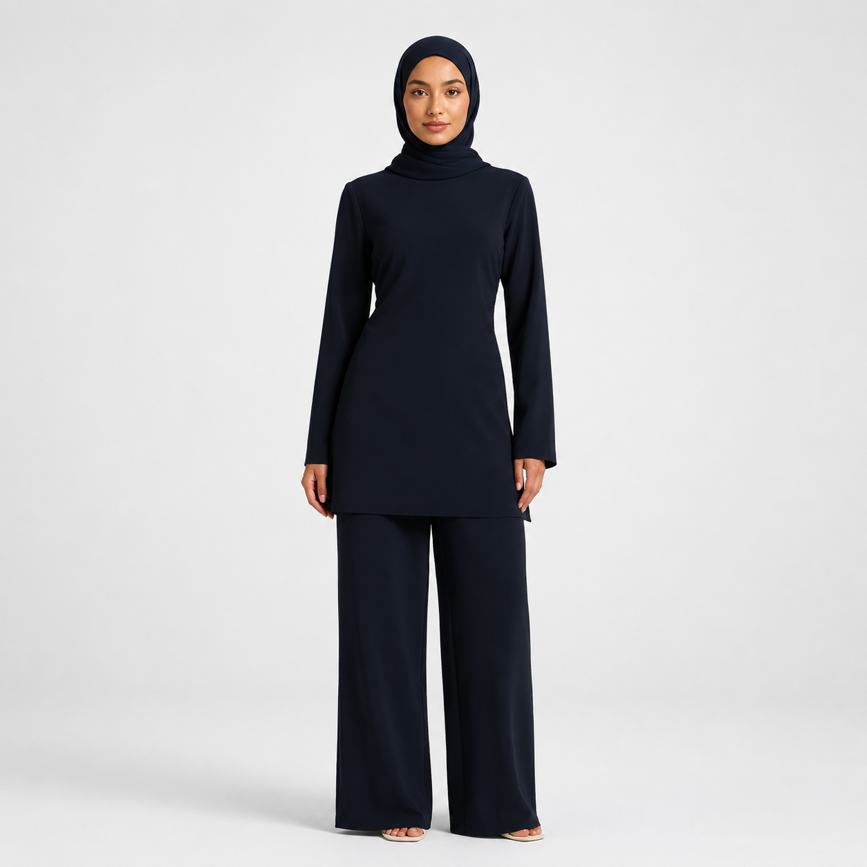 Woman wearing a black outfit with a hijab on a white background