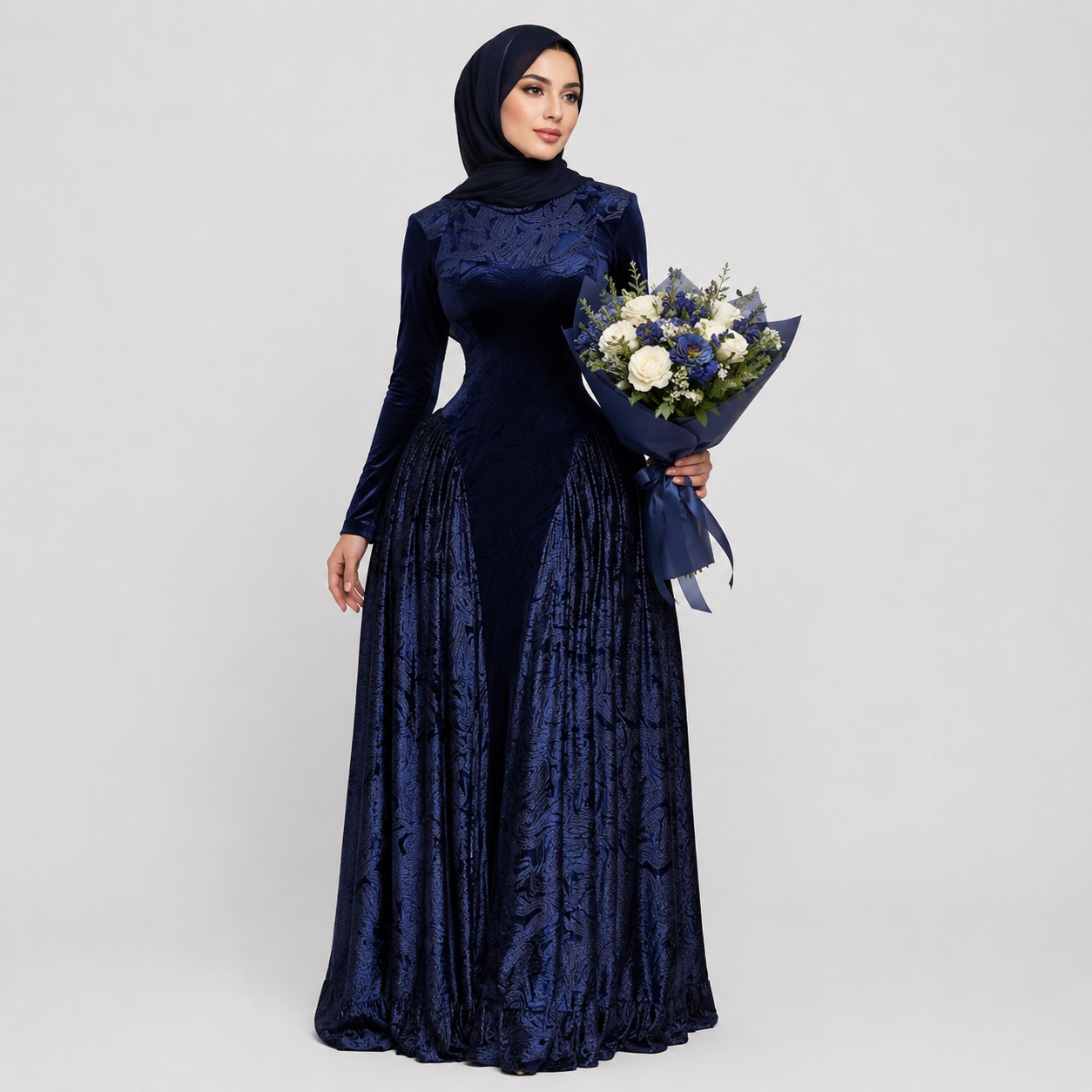 Woman in a long navy blue dress holding a bouquet of flowers on a light gray background