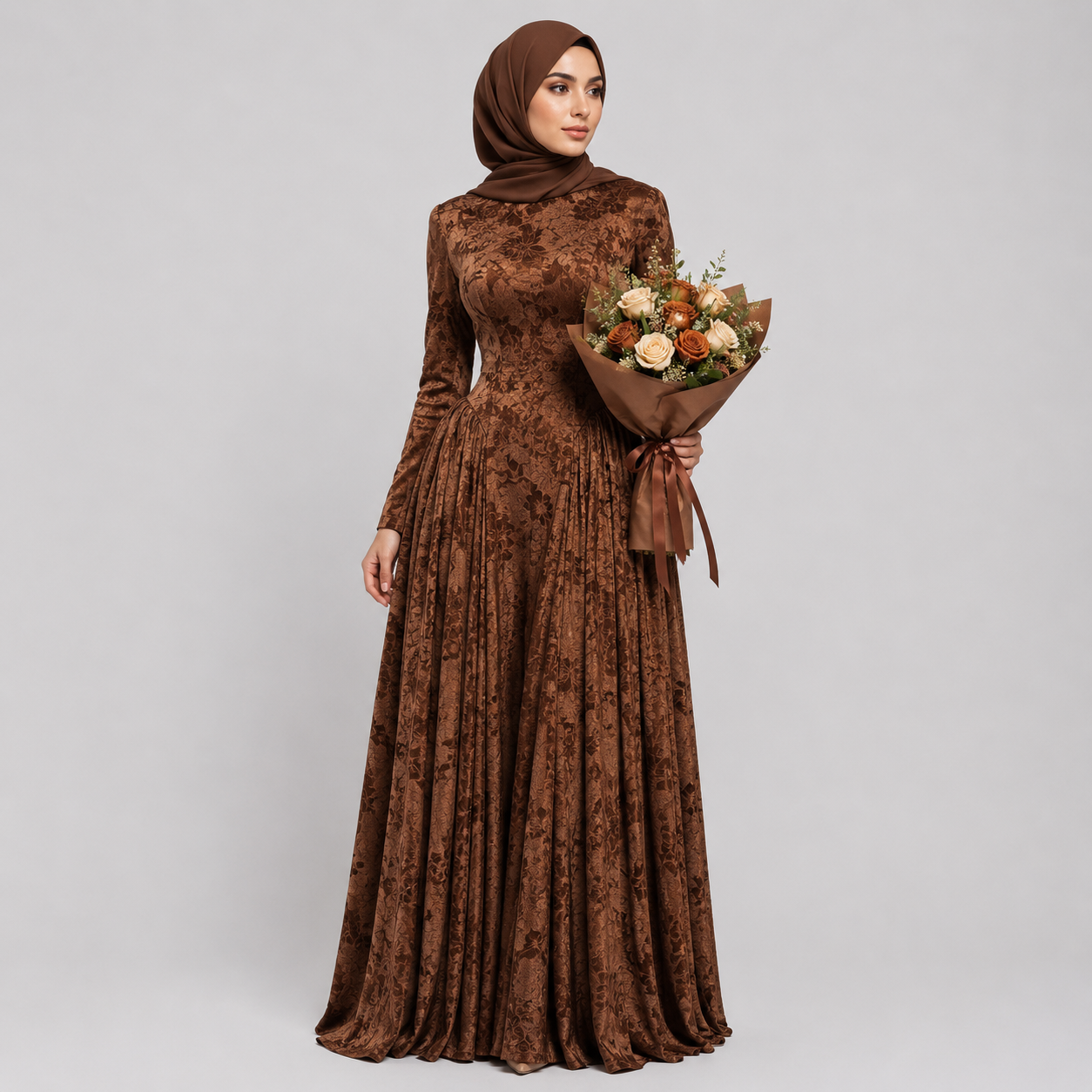 Woman wearing a brown patterned dress and hijab holding a bouquet of flowers on a light gray background