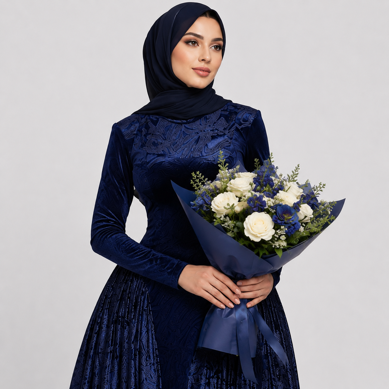 Woman in a blue dress holding a bouquet of flowers against a gray background