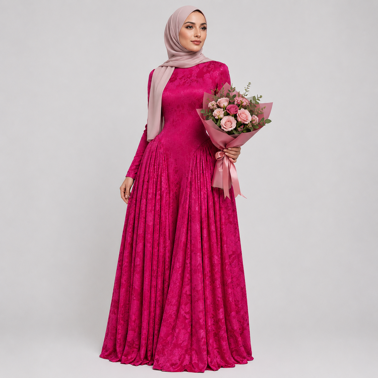 Woman in a pink dress holding a bouquet of flowers against a gray background