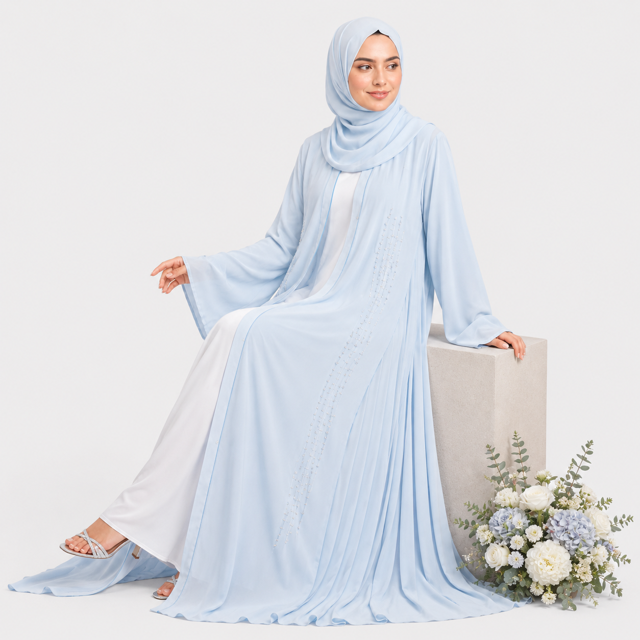 Woman wearing a light blue hijab and dress on a white background