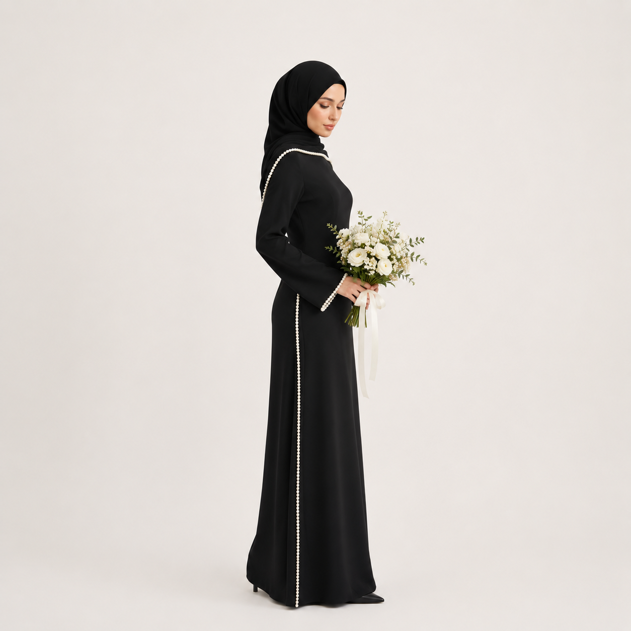 Woman in a black abaya holding flowers on a white background