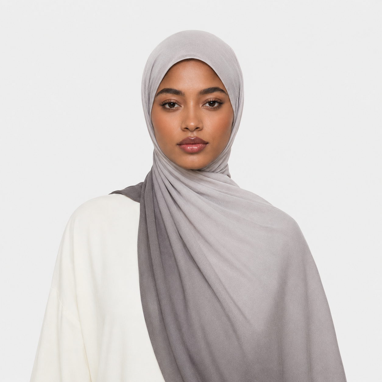 Woman wearing a gray hijab on a white background
