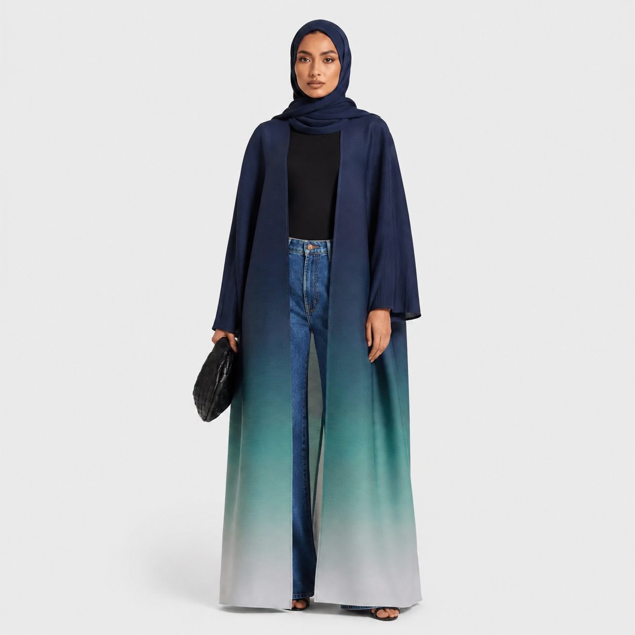 Woman wearing a long, gradient blue dress with a matching hijab on a white background