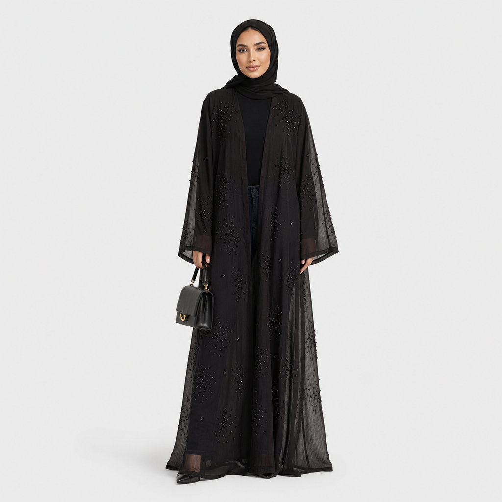 Woman wearing a black abaya with a matching hijab on a white background