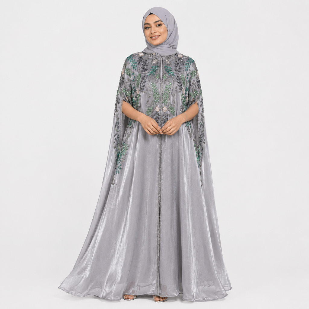 Woman wearing a gray embroidered dress with a matching hijab on a white background
