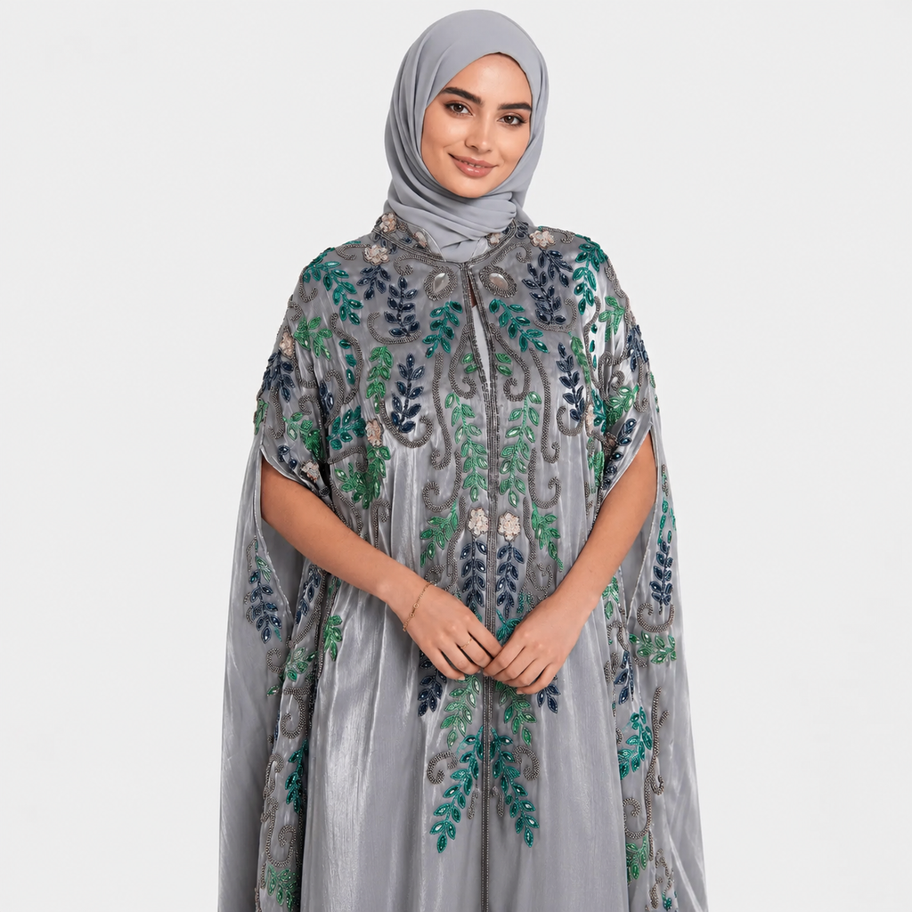 Woman wearing a gray embroidered dress with green patterns on a white background