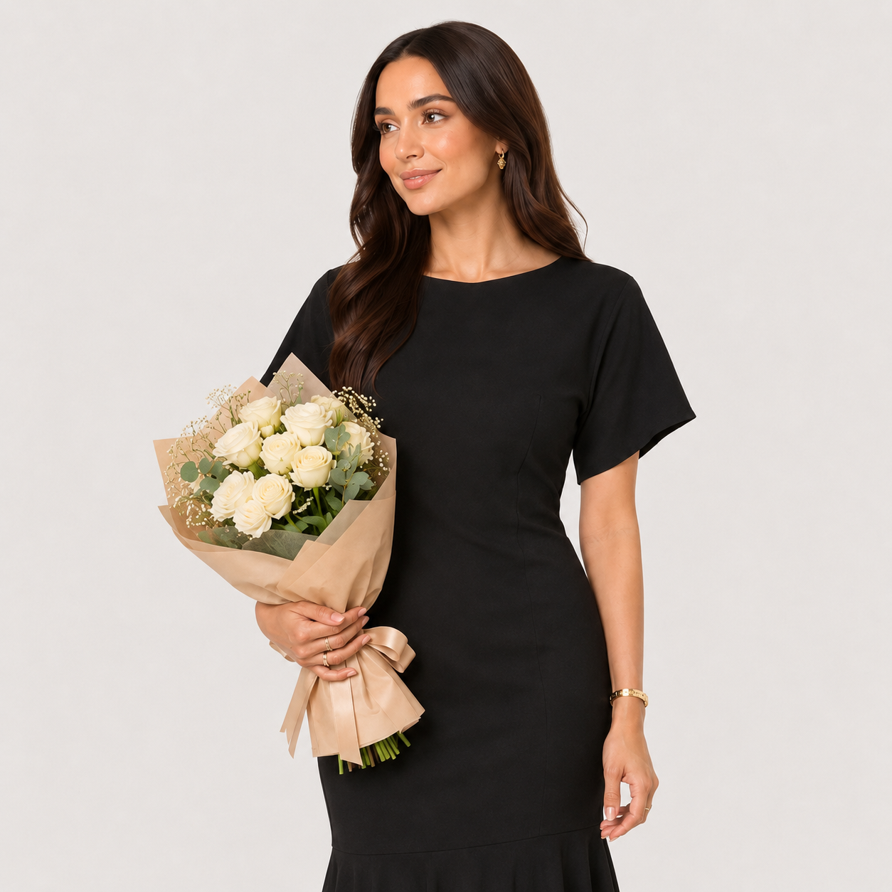 Woman holding a bouquet of white flowers against a plain background