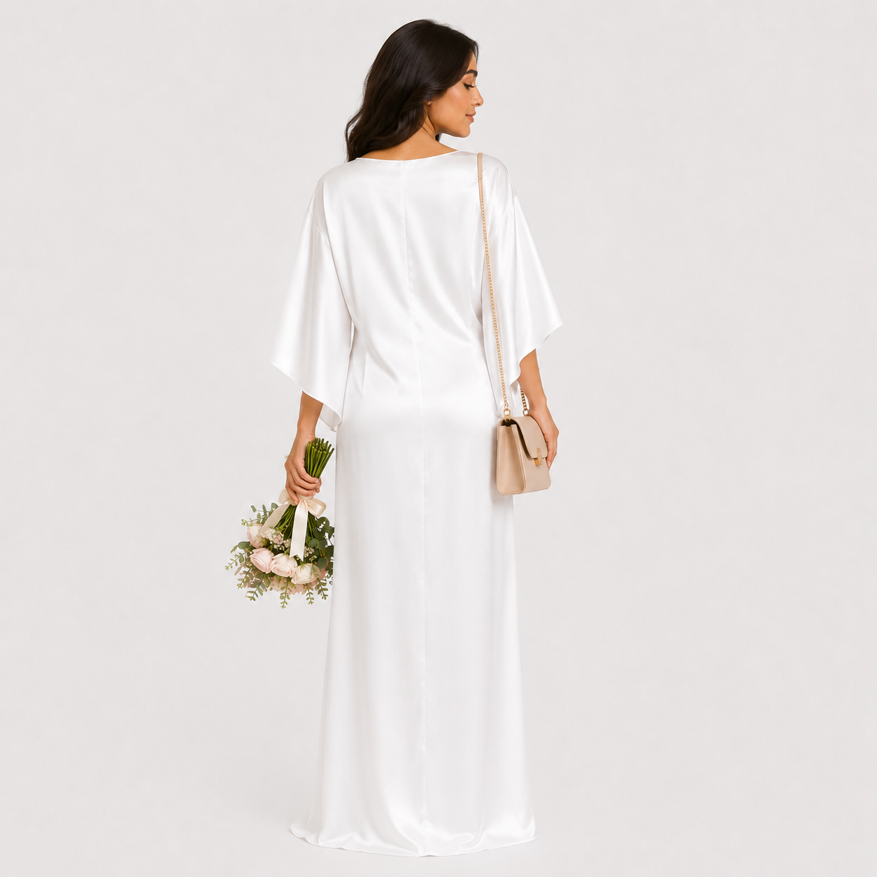 Woman in a white dress holding flowers and a beige handbag on a plain background