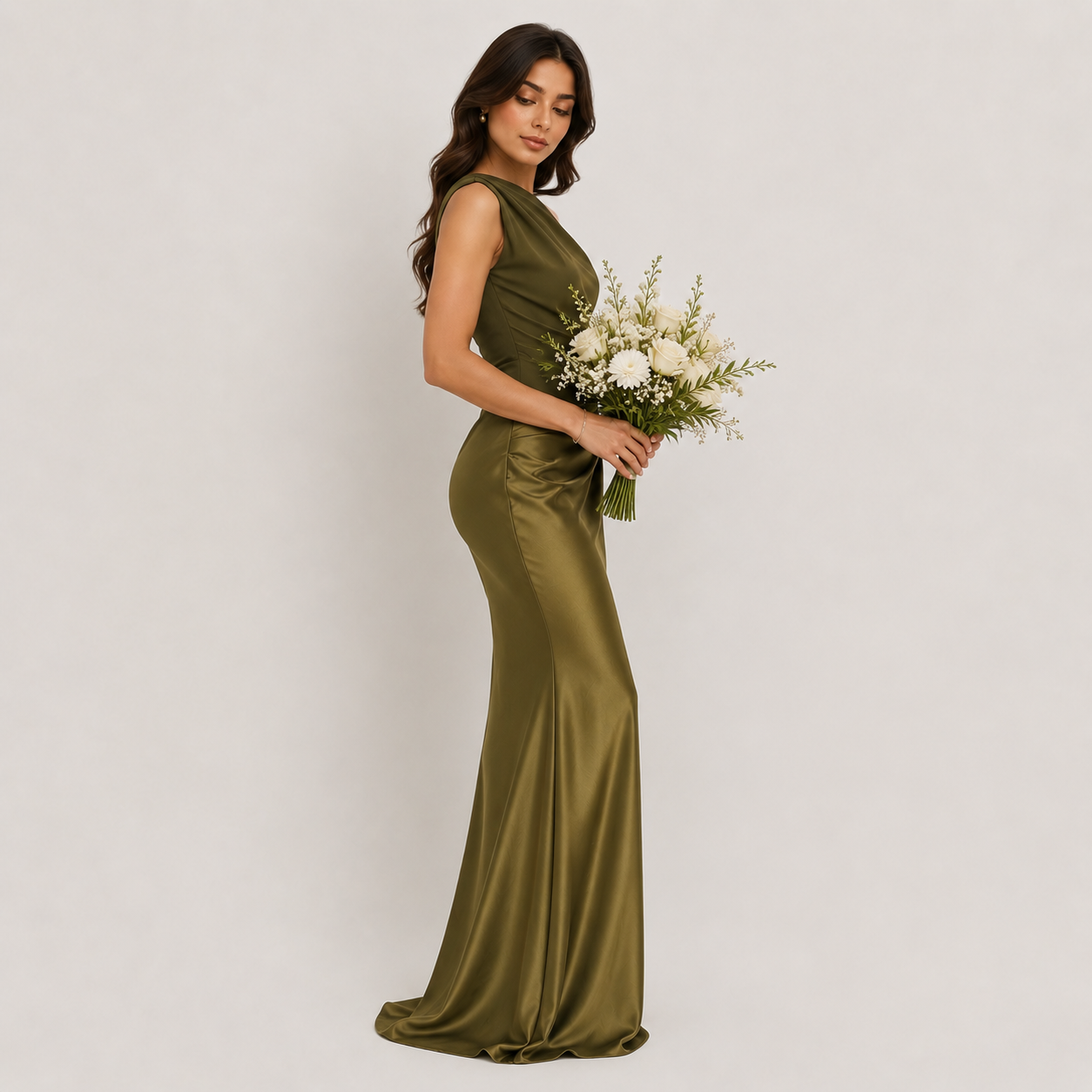 Woman in a long green dress holding flowers against a white background