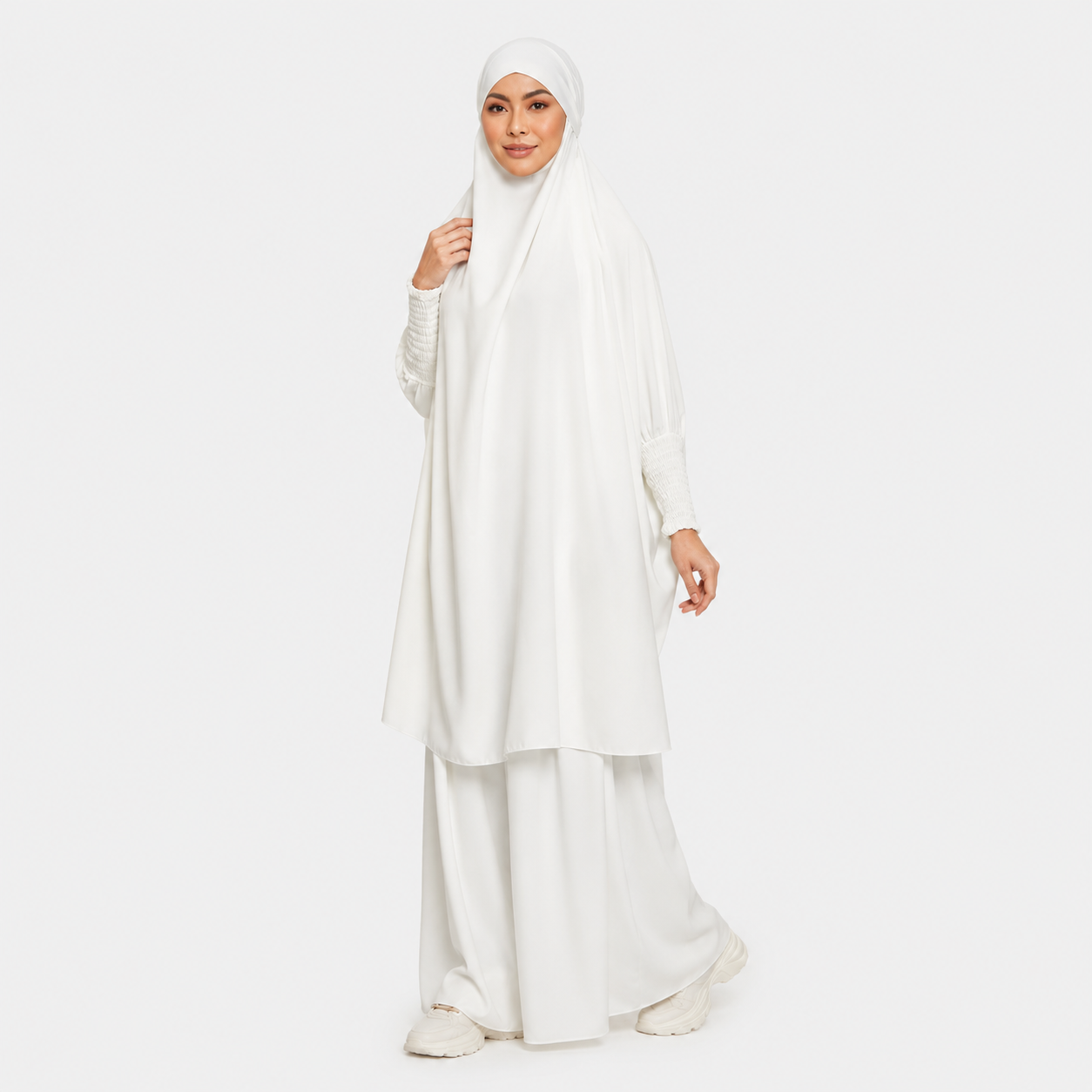 Woman wearing a white hijab and dress on a white background