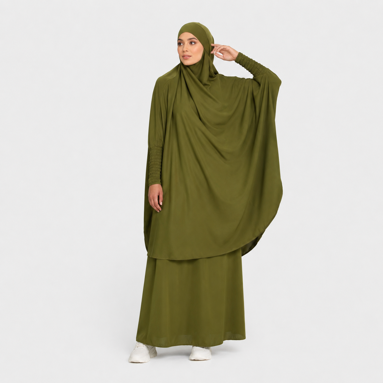 Woman wearing an olive green abaya on a white background