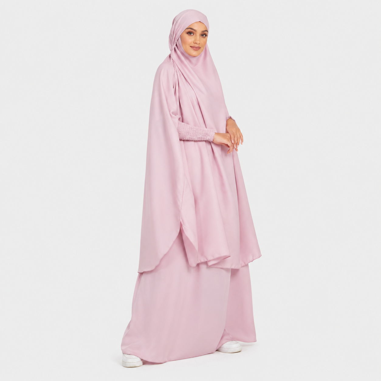 Woman wearing a pink hijab and dress on a white background