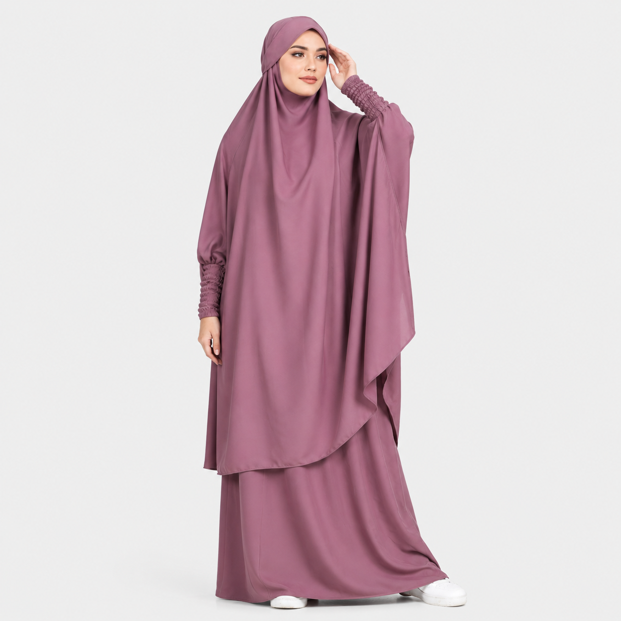 Woman wearing a mauve abaya on a white background