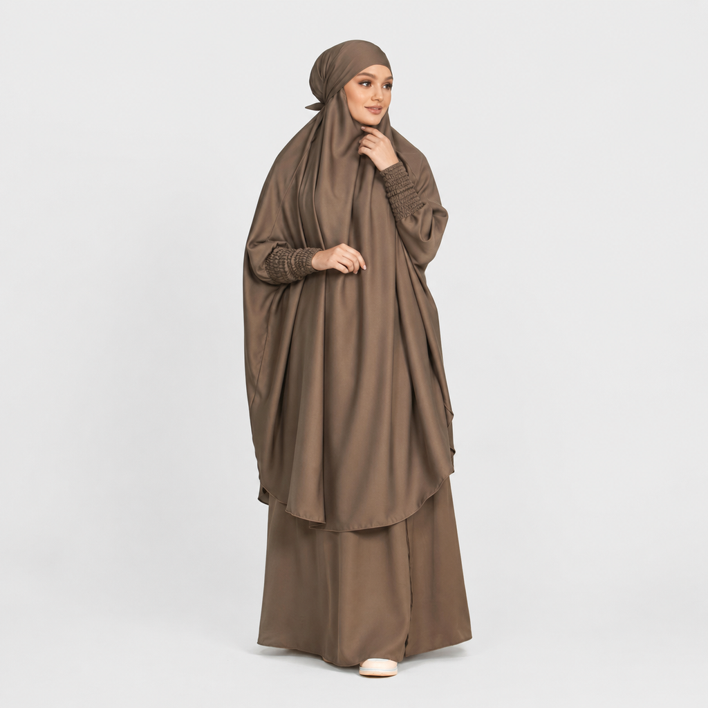 Woman wearing a brown abaya and hijab on a white background