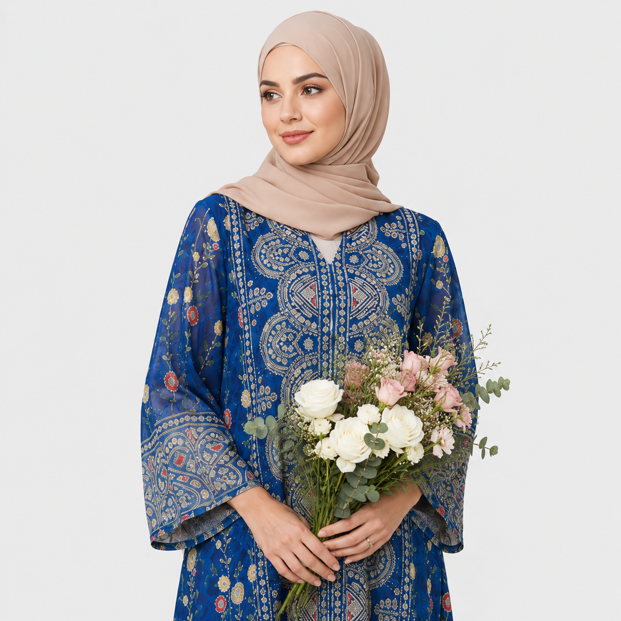 Woman wearing a blue patterned dress holding flowers against a white background