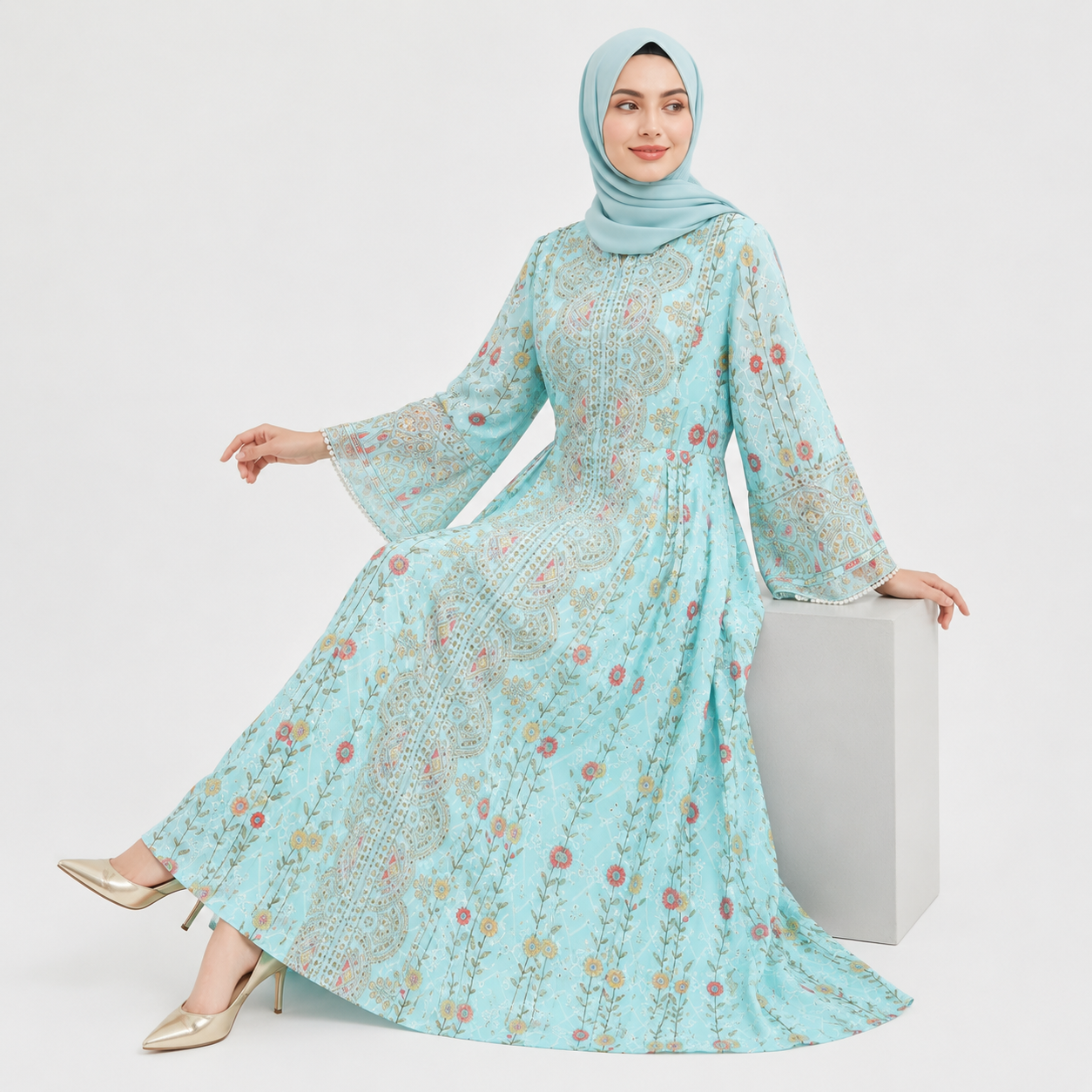 Woman wearing a light blue floral dress and hijab on a white background