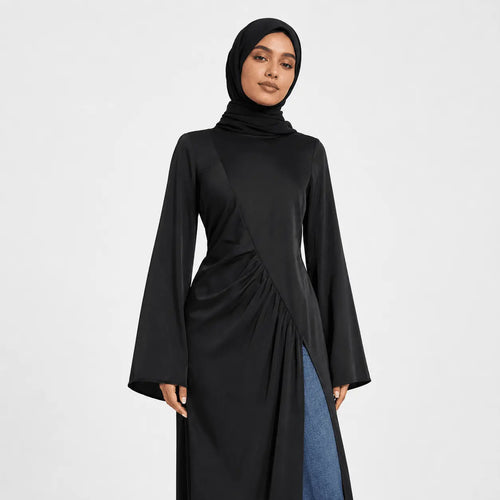 Woman wearing a black long-sleeve dress with a high neckline on a white background