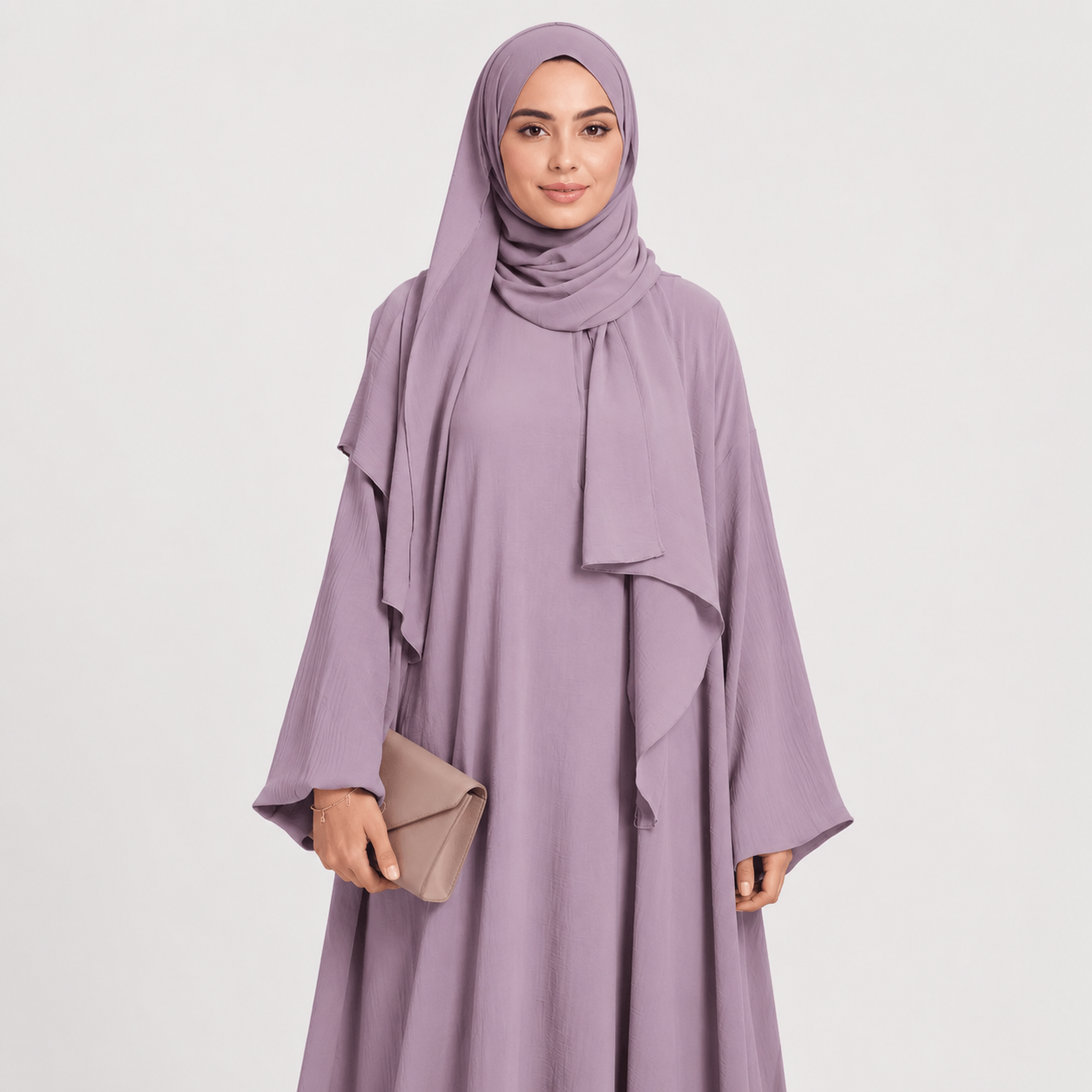Woman wearing a light purple abaya with a matching hijab on a white background