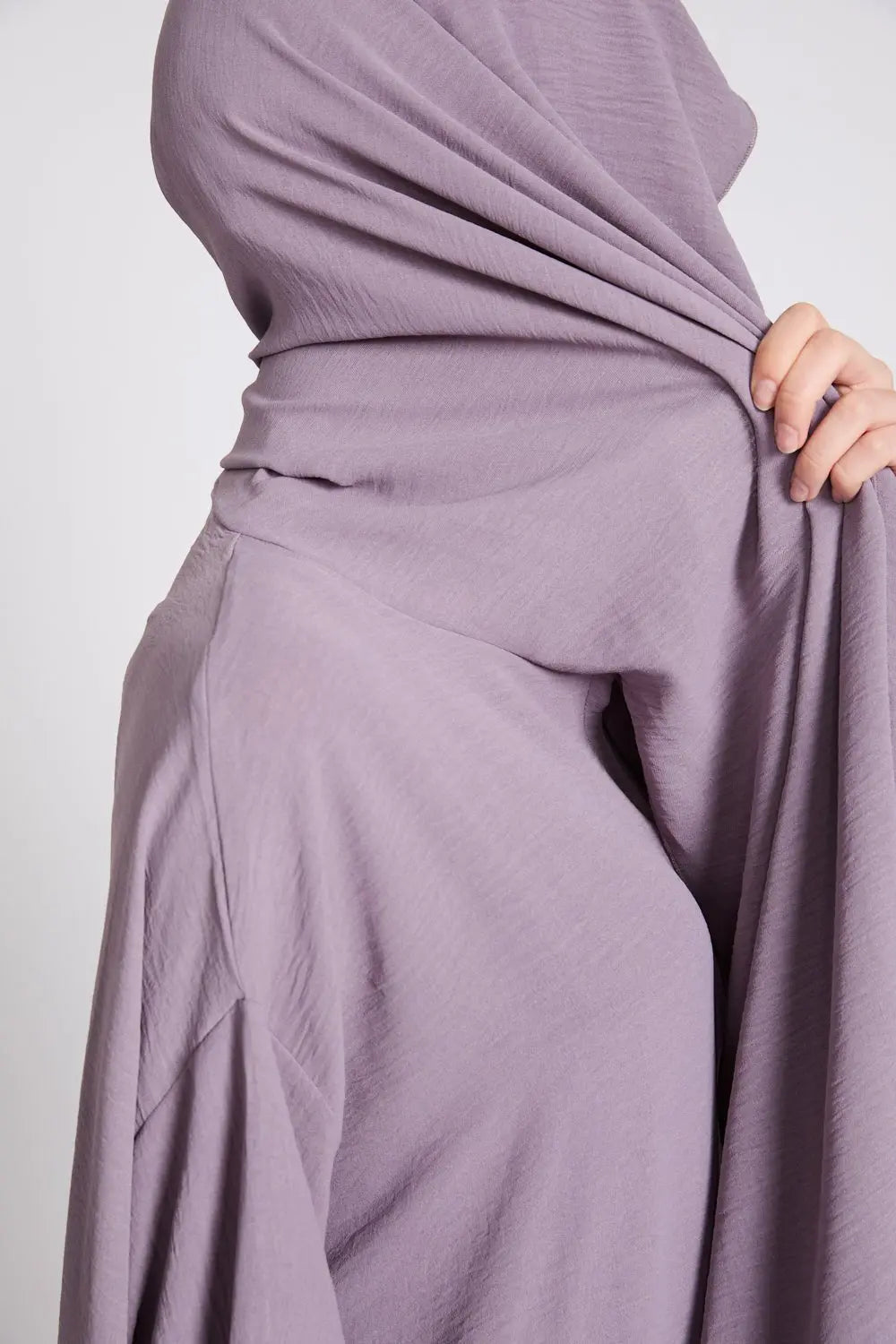 Lavender hijab being held up against a plain background