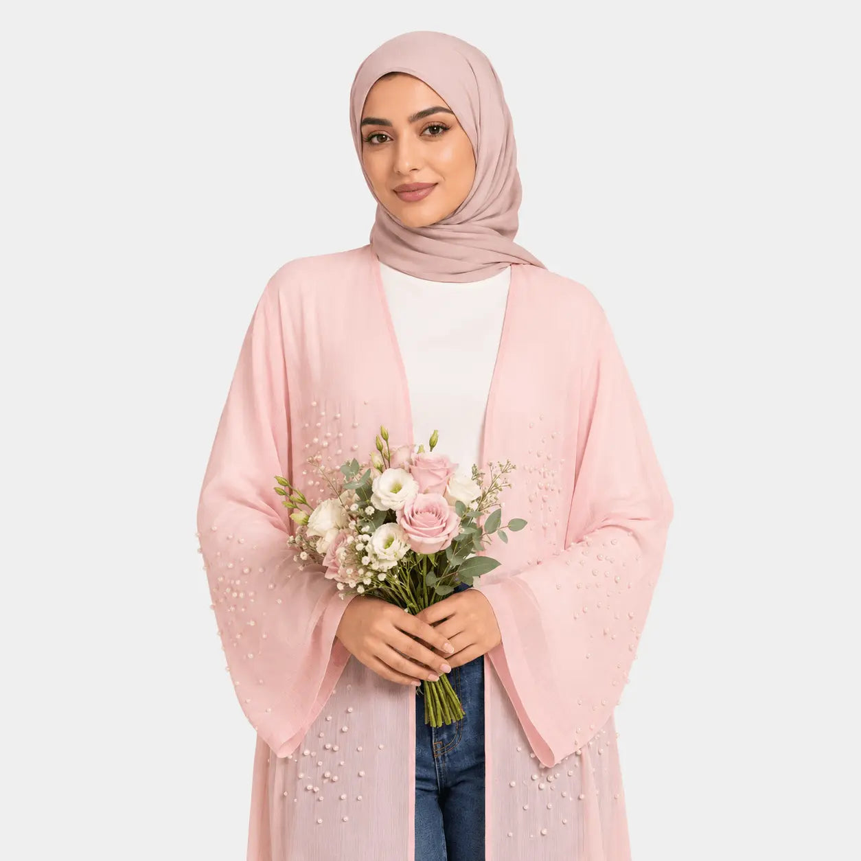 Woman wearing a pink hijab and holding a bouquet of flowers against a white background
