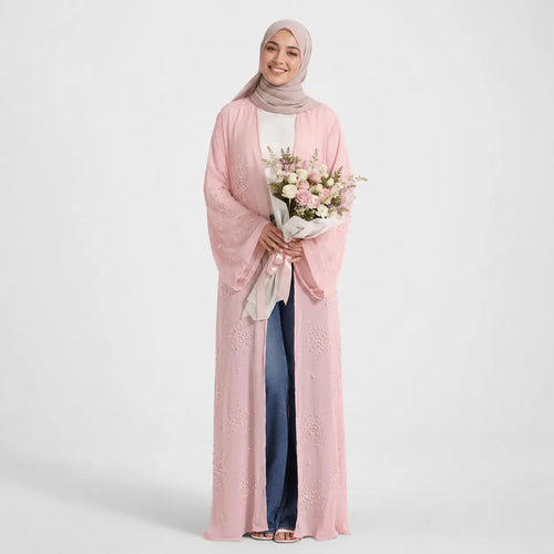 Woman wearing a pink abaya holding flowers on a white background