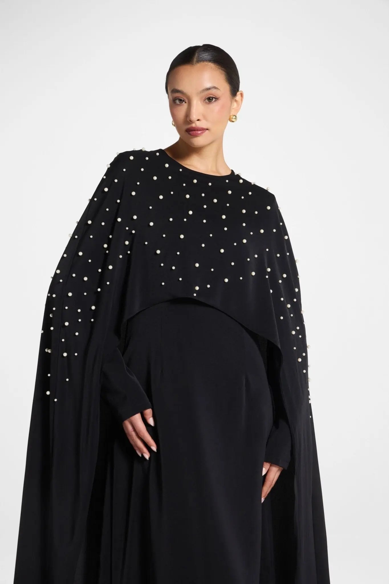 Woman wearing a black dress with star patterns on a white background