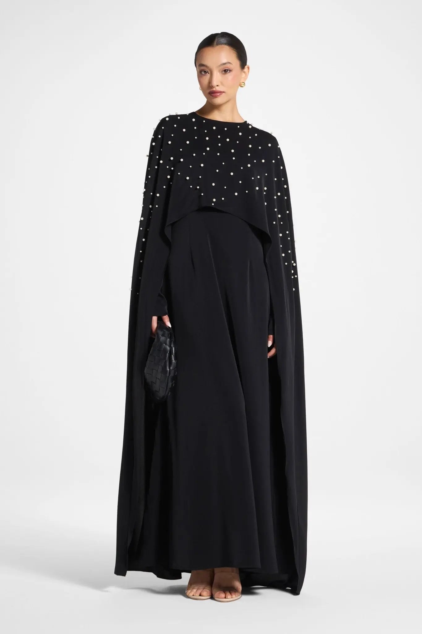 Woman wearing a black dress with star patterns on a white background