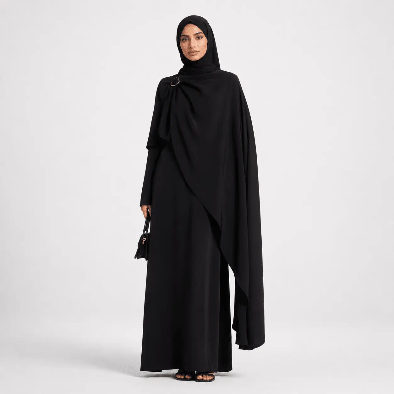 Woman wearing a black abaya on a white background