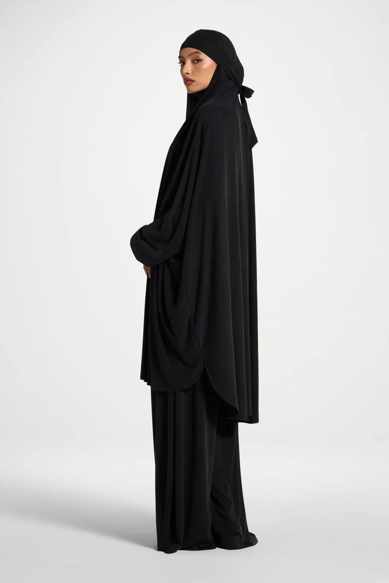 Person wearing a black abaya on a white background