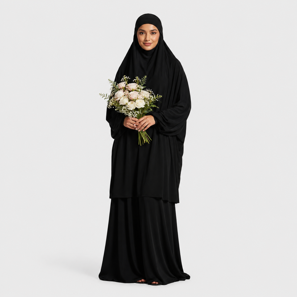 Woman in a black abaya holding a bouquet of flowers on a white background