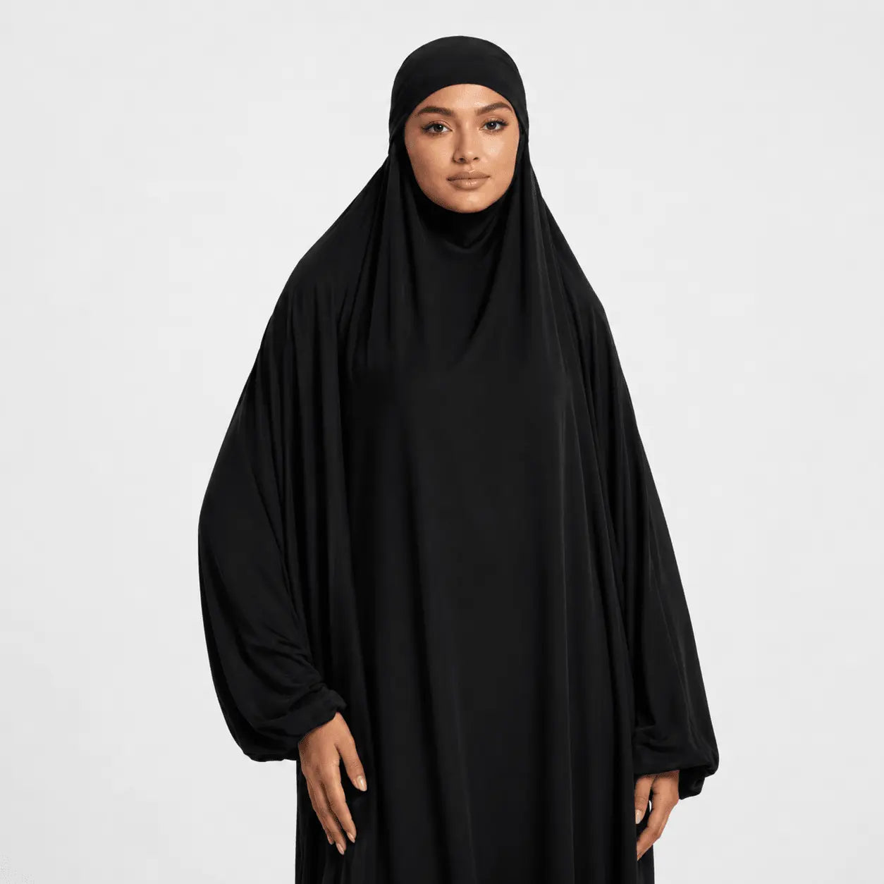 Person wearing a black abaya on a white background