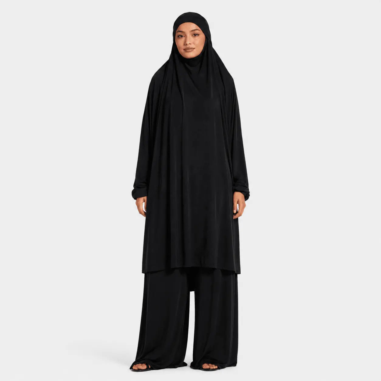 Person wearing a black outfit on a white background