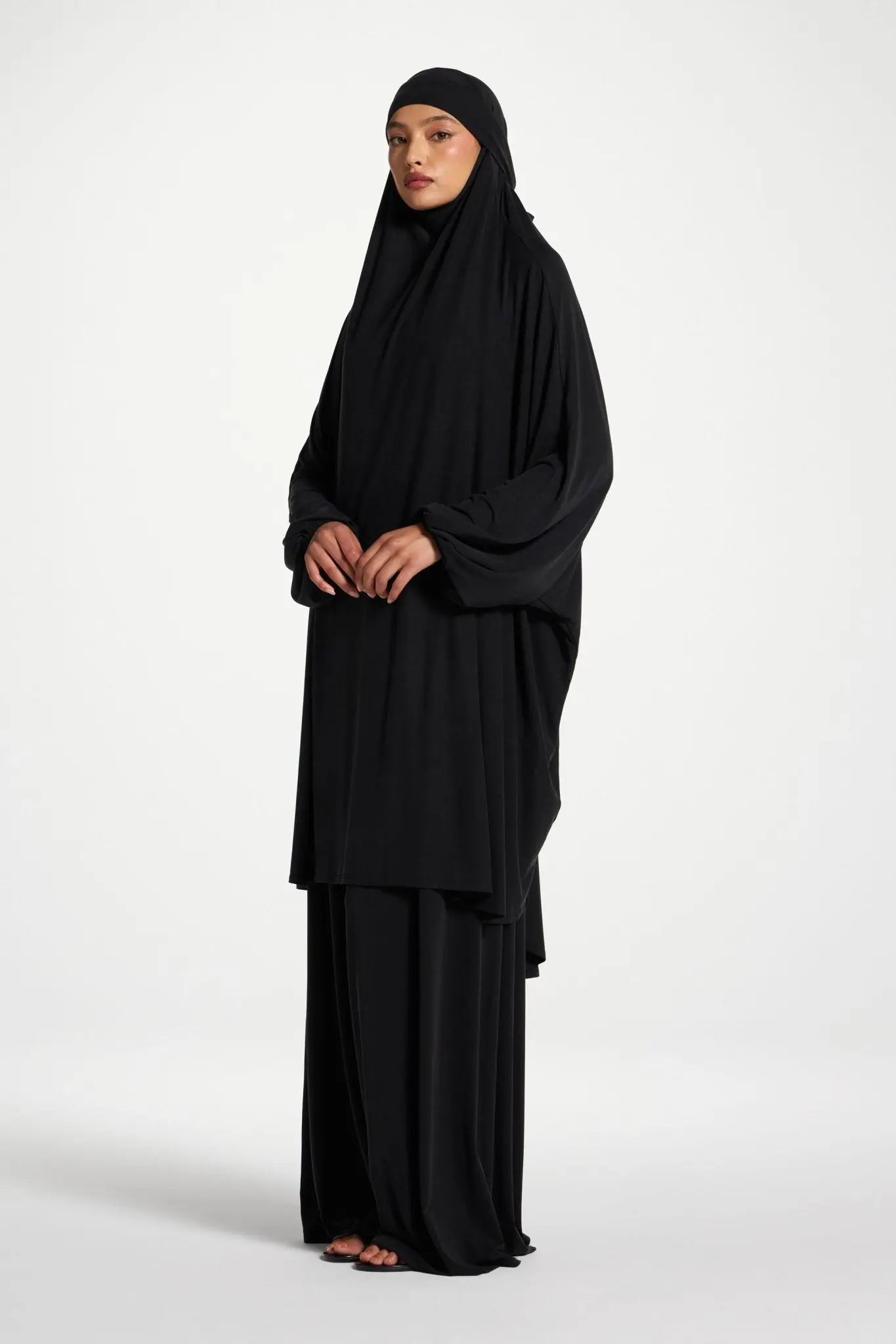 Person wearing a black abaya on a white background