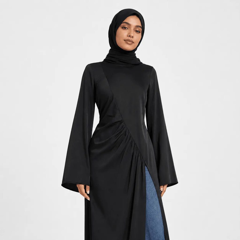 Woman wearing a black long-sleeve dress with a high neckline on a white background