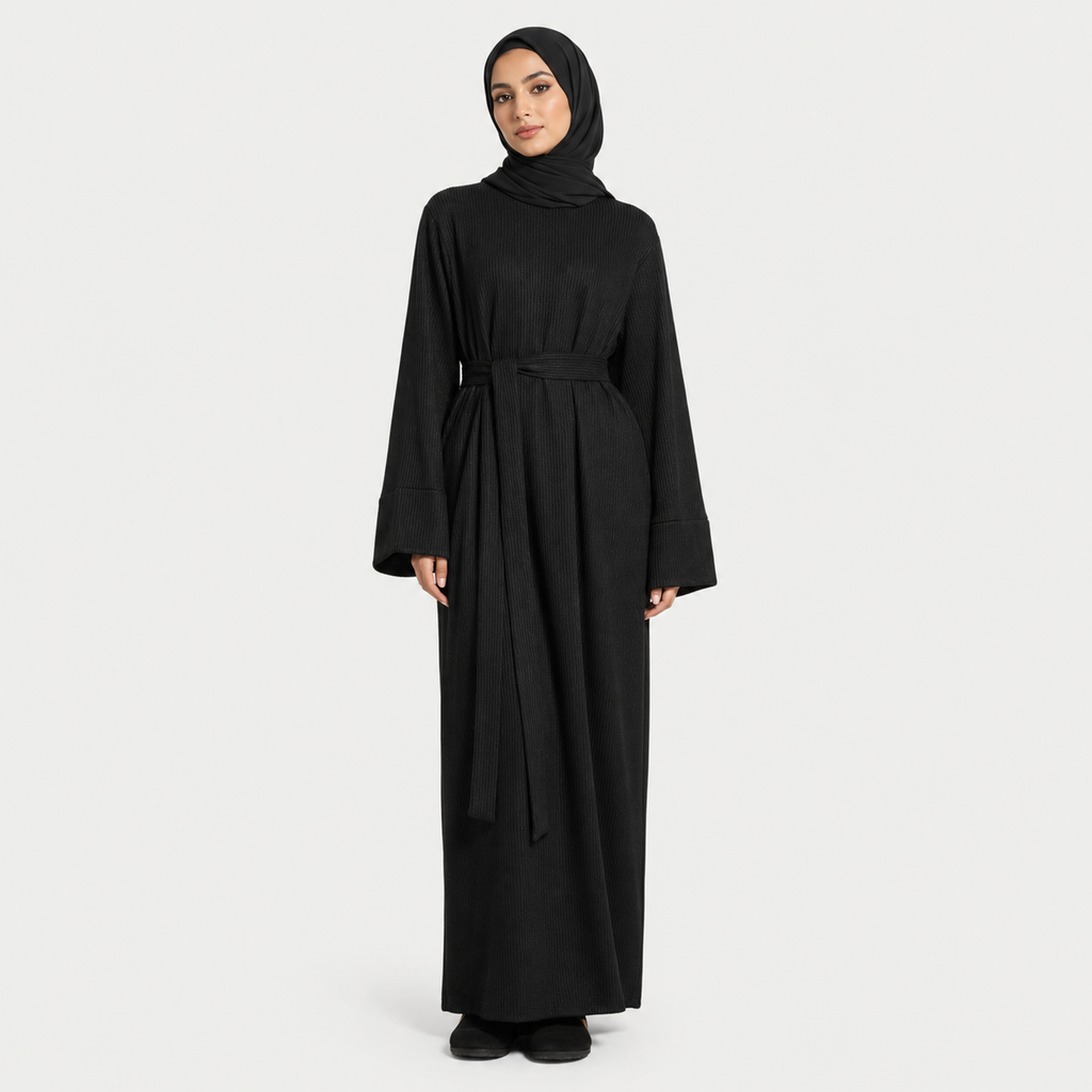 Woman wearing a black abaya on a white background