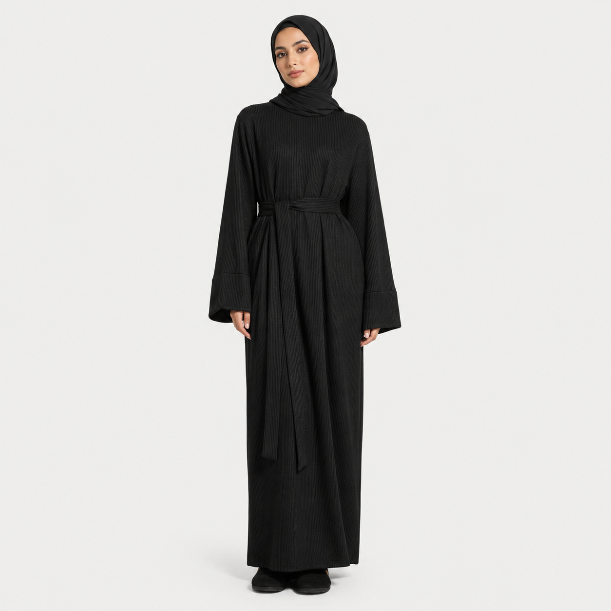 Woman wearing a black abaya on a white background