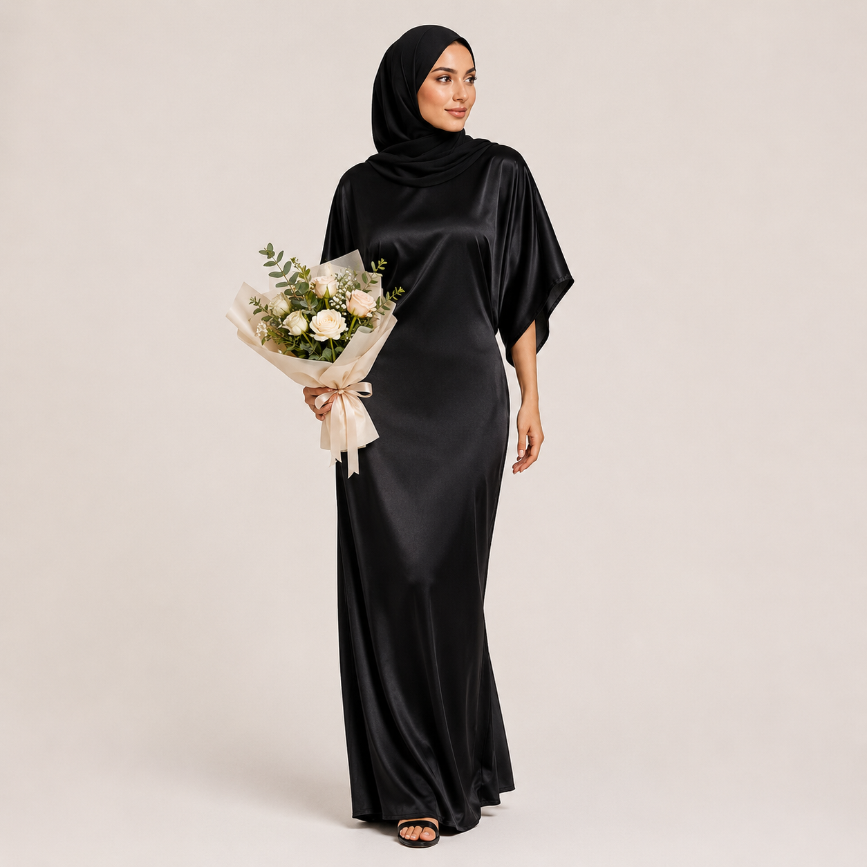 Woman in a black abaya holding a bouquet of flowers on a plain background
