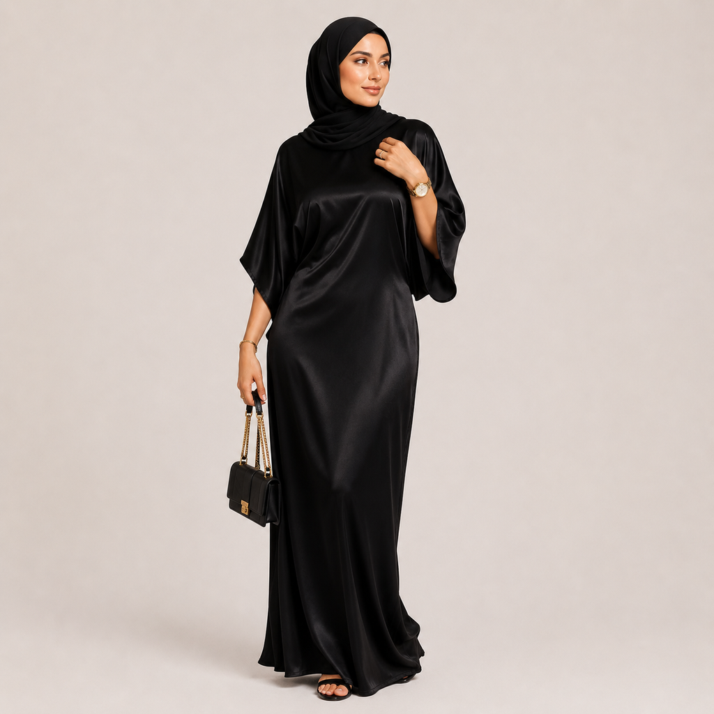 Woman wearing a black abaya with a matching hijab on a beige background
