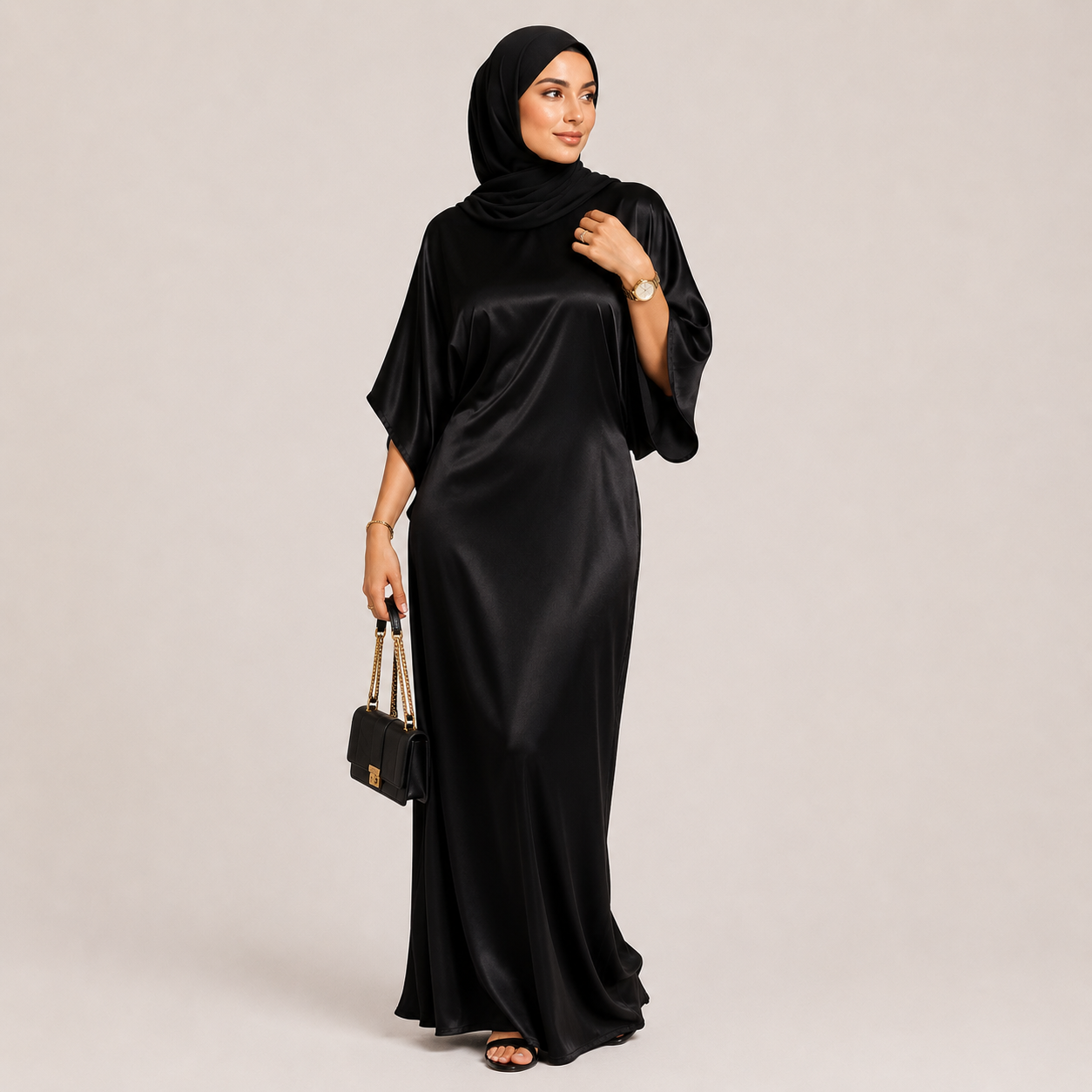 Woman wearing a black abaya with a matching hijab on a beige background