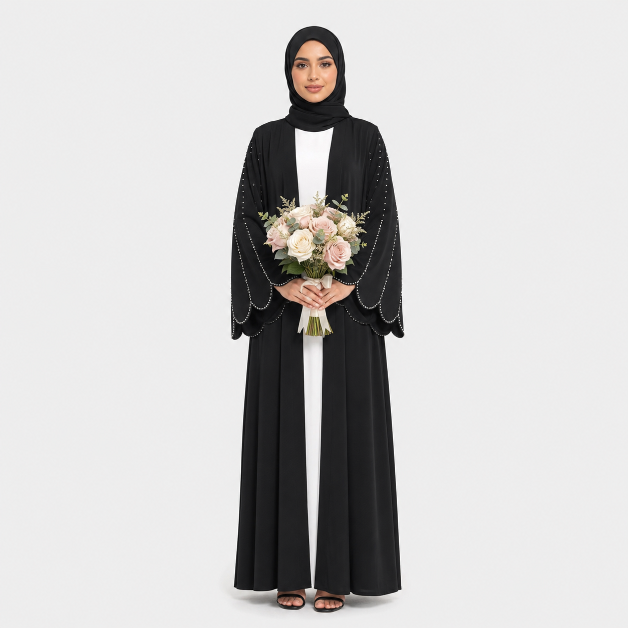 Woman in a black abaya holding flowers on a white background